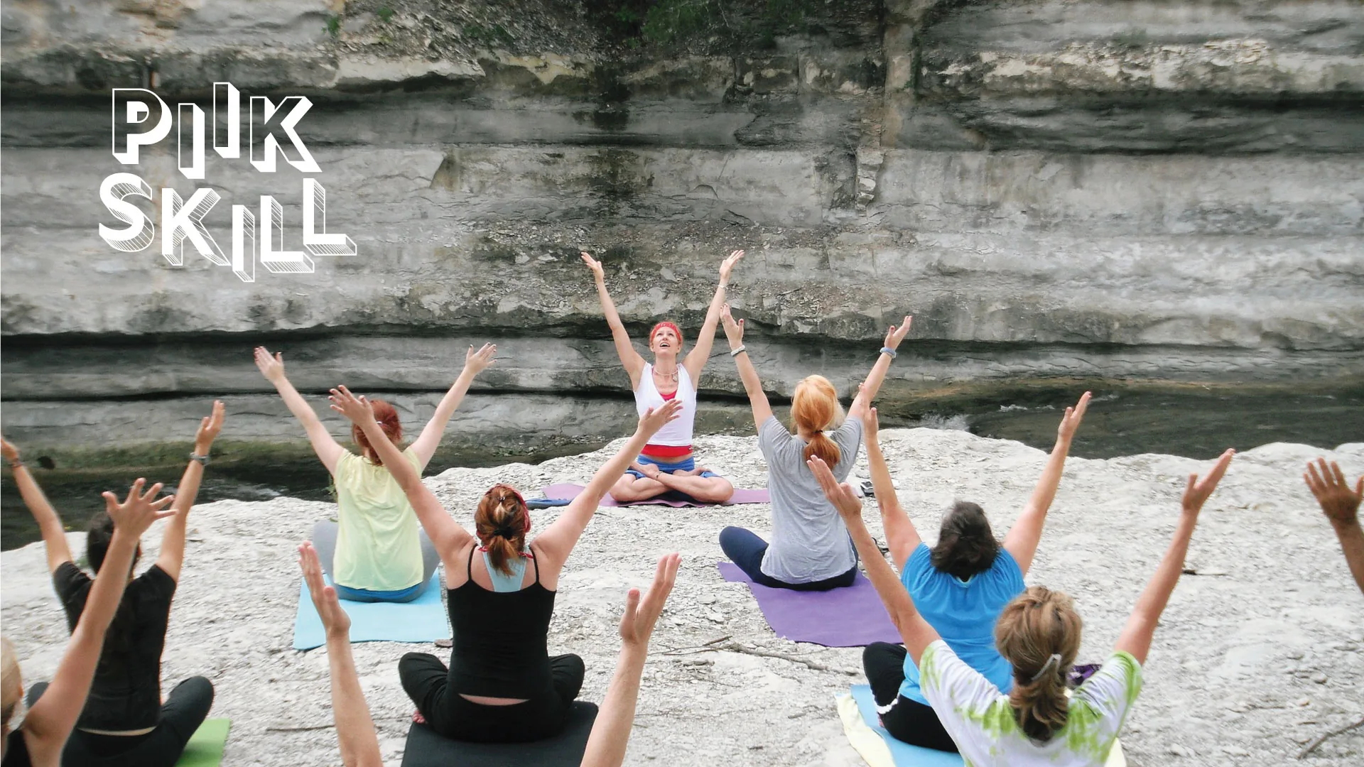 A group practising yoga on rock, under the PiikSkill mark